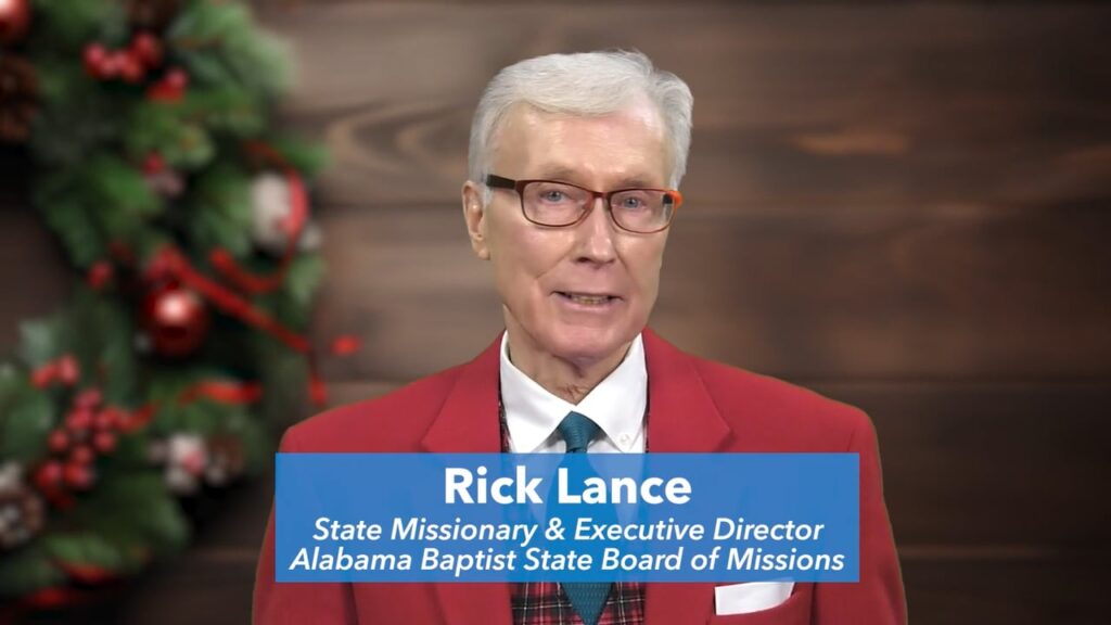 Dr. Rick Lance standing in front of a Christmas backdrop